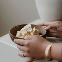 Kanobe's founder holding a bowl of raw cocoa butter.