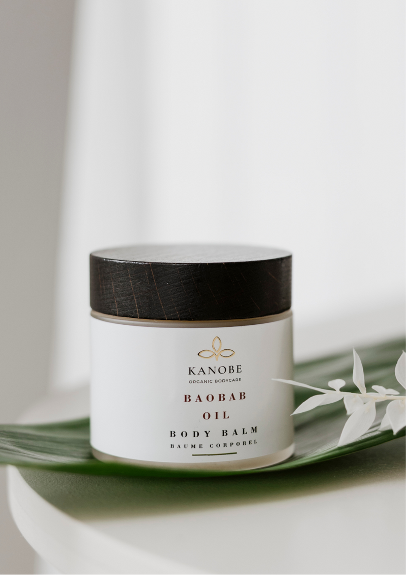 Jar of Kanore Baobab Oil Body Balm on a white surface with a blurred background